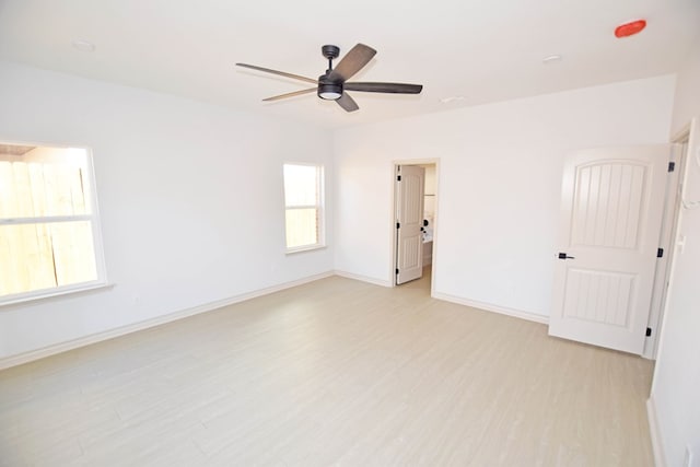 empty room featuring light hardwood / wood-style flooring, a wealth of natural light, and ceiling fan