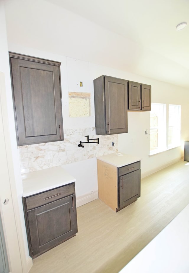 kitchen featuring dark brown cabinets and light hardwood / wood-style floors