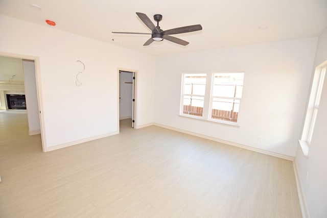 empty room with light hardwood / wood-style flooring and ceiling fan