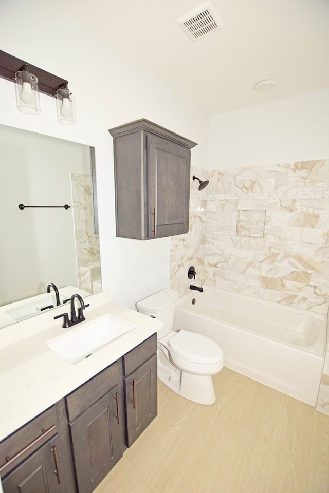 full bathroom with vanity, toilet, tiled shower / bath, and hardwood / wood-style flooring