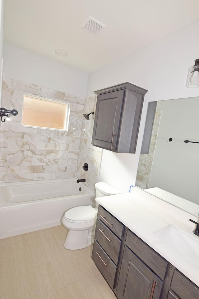 full bathroom featuring vanity, toilet, and tiled shower / bath