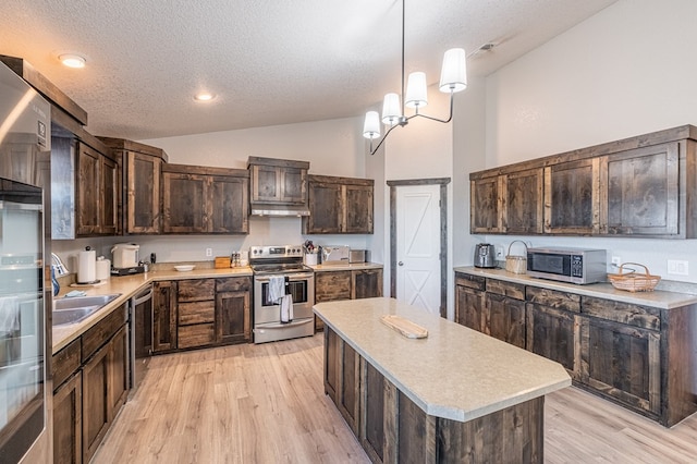 kitchen with lofted ceiling, appliances with stainless steel finishes, dark brown cabinetry, and hanging light fixtures