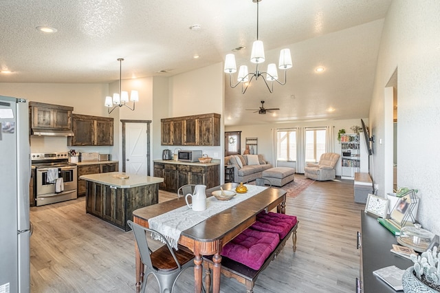 dining space with high vaulted ceiling, ceiling fan with notable chandelier, a textured ceiling, and light hardwood / wood-style floors