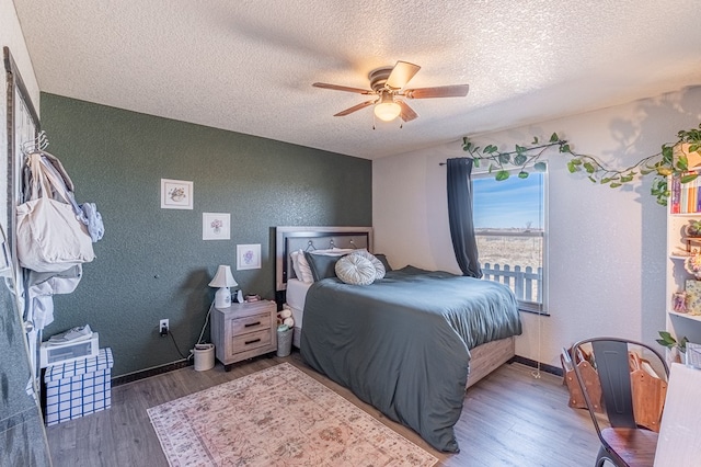 bedroom featuring hardwood / wood-style floors, a textured ceiling, and ceiling fan