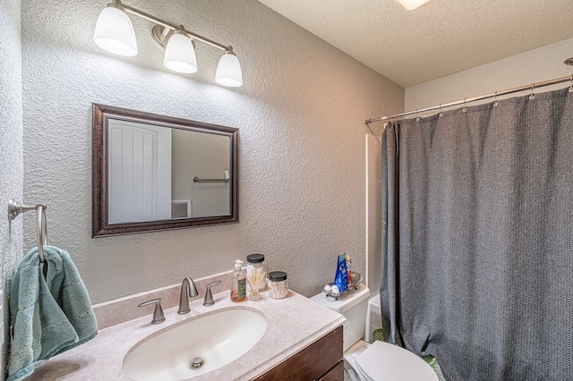 bathroom with a shower with curtain, vanity, toilet, and a textured ceiling