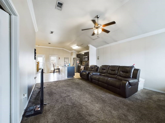 living room with lofted ceiling, ornamental molding, ceiling fan, and dark colored carpet