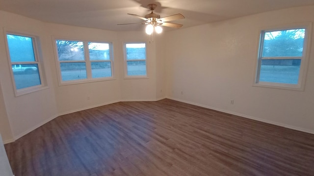 spare room featuring plenty of natural light, dark wood-type flooring, and ceiling fan