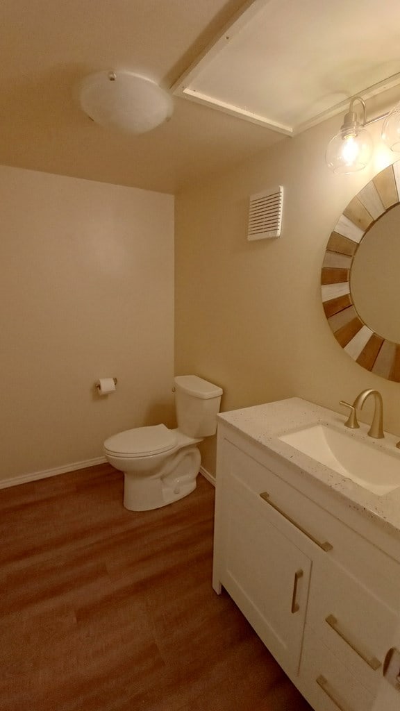 bathroom featuring hardwood / wood-style flooring, vanity, and toilet