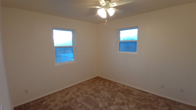 carpeted spare room with plenty of natural light and ceiling fan