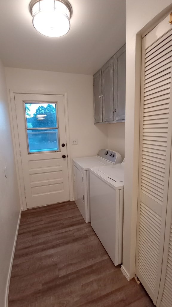 laundry room featuring hardwood / wood-style flooring, cabinets, and independent washer and dryer