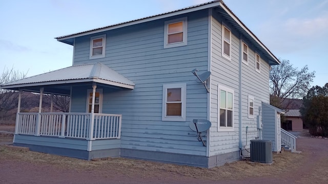 rear view of property with covered porch and central AC unit