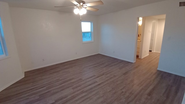 empty room with ceiling fan and dark wood-type flooring