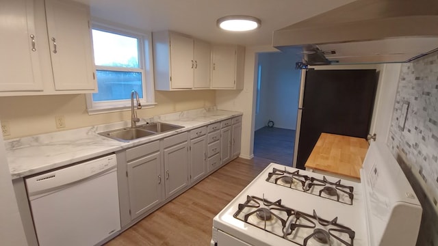 kitchen with white appliances, ventilation hood, sink, light hardwood / wood-style floors, and white cabinetry