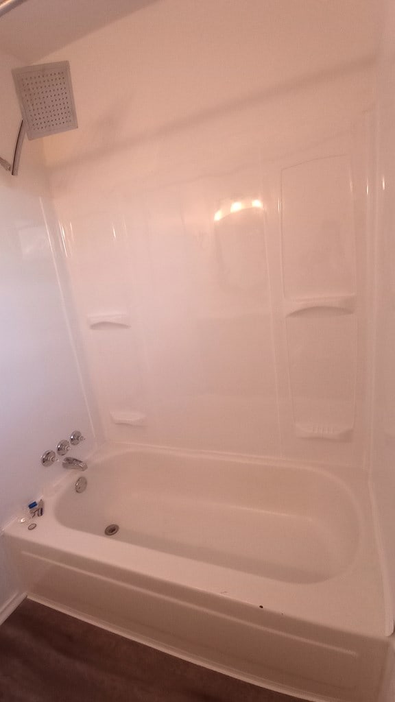 bathroom featuring wood-type flooring and shower / tub combination