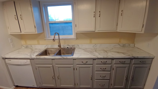 kitchen featuring dishwasher, white cabinets, light stone countertops, and sink