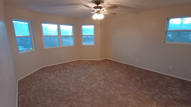 empty room with carpet flooring, plenty of natural light, and ceiling fan