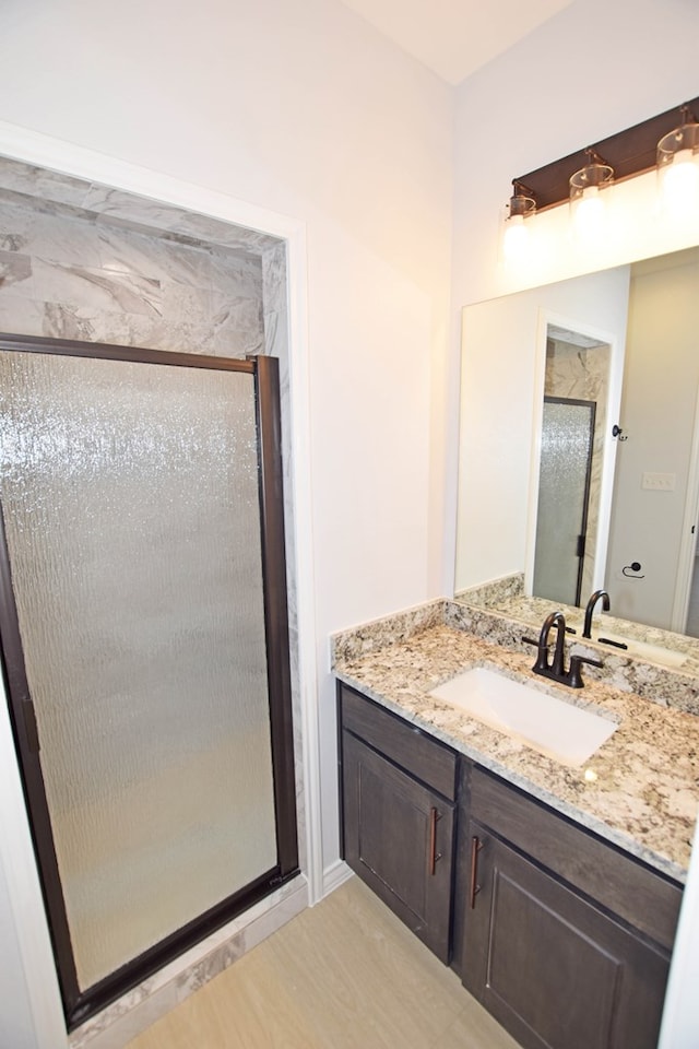 bathroom with vanity and a shower with shower door