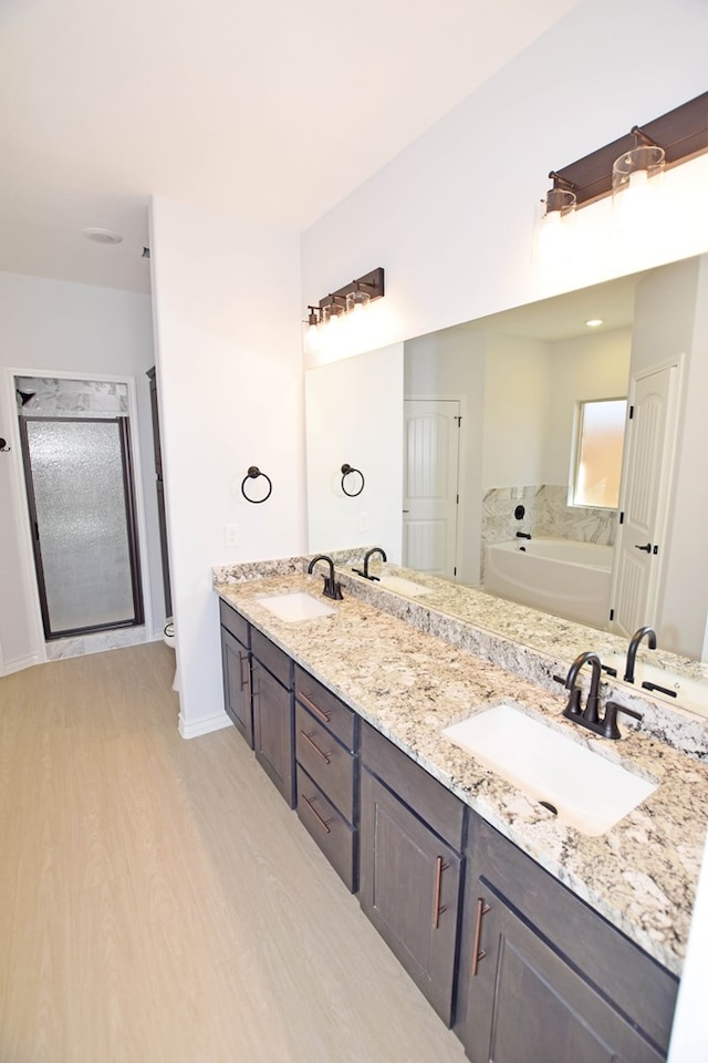 full bathroom featuring hardwood / wood-style flooring, vanity, toilet, and shower with separate bathtub