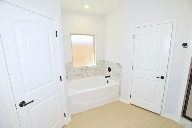 bathroom featuring hardwood / wood-style flooring and a washtub