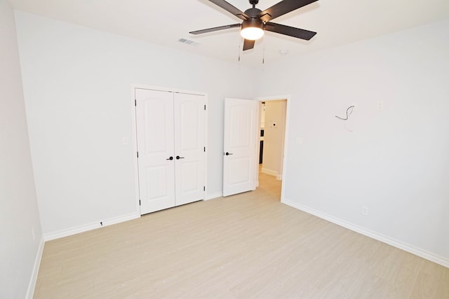 unfurnished bedroom with light hardwood / wood-style floors, a closet, and ceiling fan