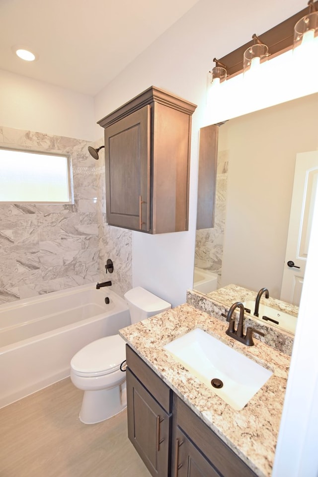 full bathroom featuring tiled shower / bath, vanity, toilet, and wood-type flooring