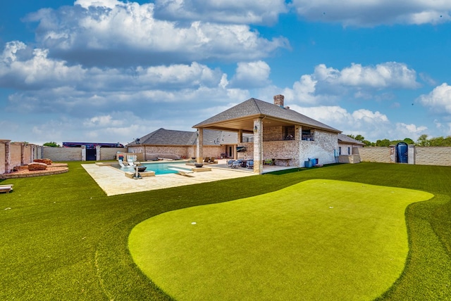 rear view of house with a fenced in pool and a patio area