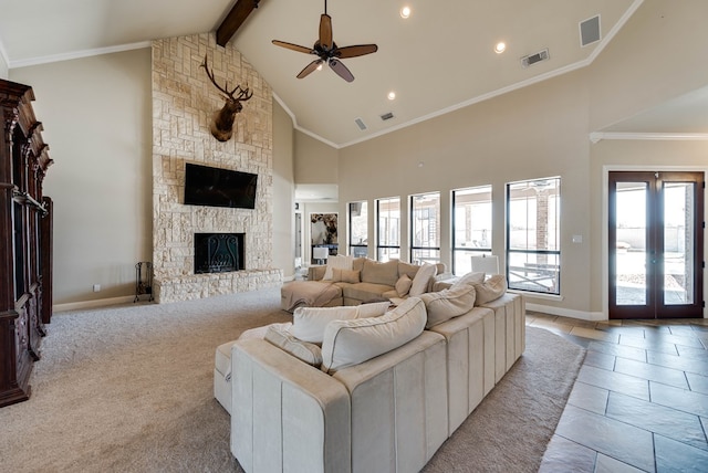 living room featuring light carpet, ceiling fan, high vaulted ceiling, beamed ceiling, and a stone fireplace