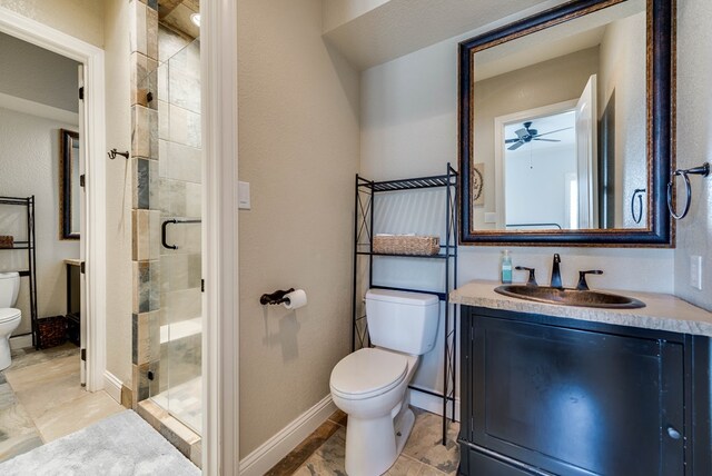 bathroom featuring ceiling fan, a textured ceiling, an enclosed shower, toilet, and vanity