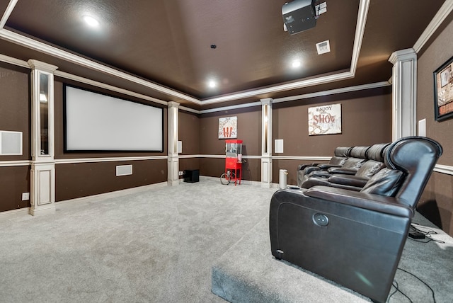 cinema with carpet floors, a tray ceiling, ornate columns, and ornamental molding