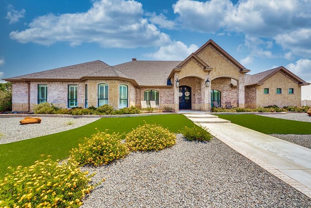 french provincial home featuring a front yard