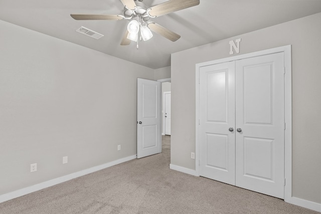 unfurnished bedroom featuring ceiling fan, a closet, and light carpet