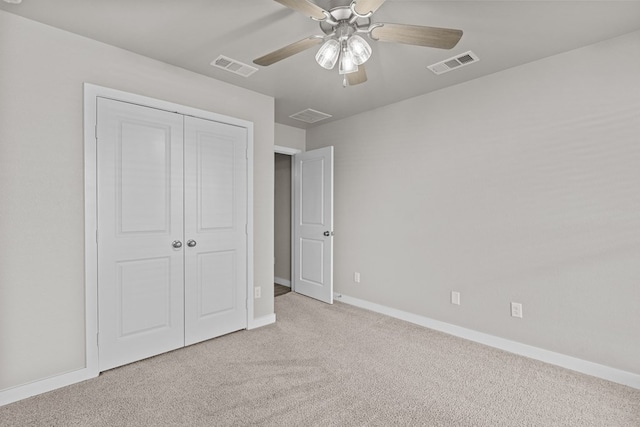 unfurnished bedroom with ceiling fan, light carpet, and a closet