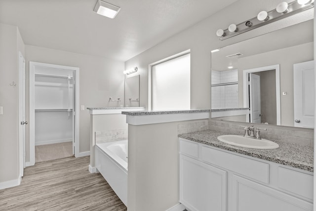 bathroom with separate shower and tub, vanity, a textured ceiling, and hardwood / wood-style flooring