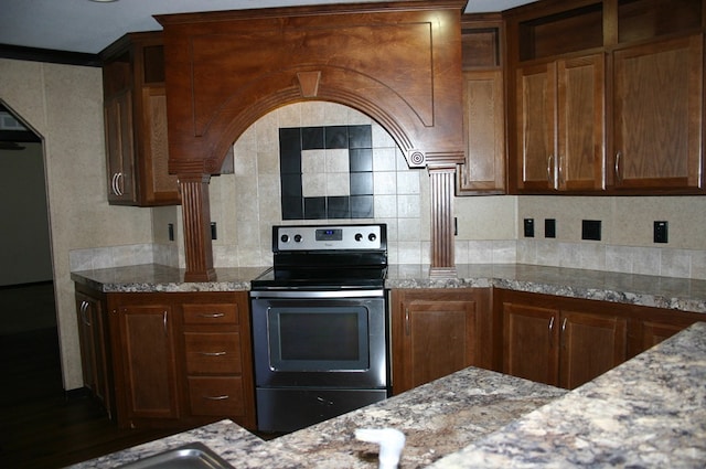 kitchen with tasteful backsplash, stainless steel electric range oven, light stone countertops, and dark hardwood / wood-style floors