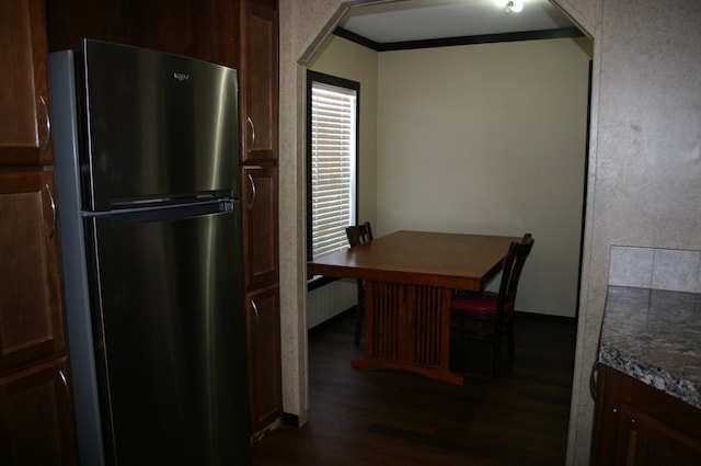 kitchen with stainless steel fridge, dark hardwood / wood-style flooring, and crown molding