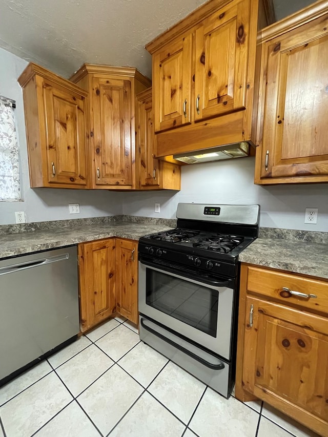 kitchen featuring stainless steel appliances, dark countertops, and brown cabinets