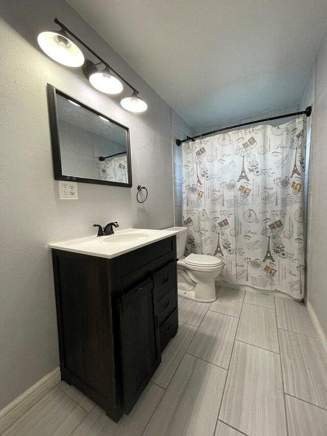 bathroom featuring toilet, baseboards, vanity, and a shower with curtain