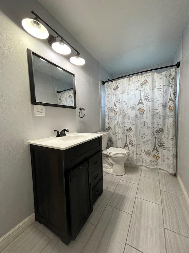 bathroom featuring toilet, baseboards, a shower with shower curtain, and vanity