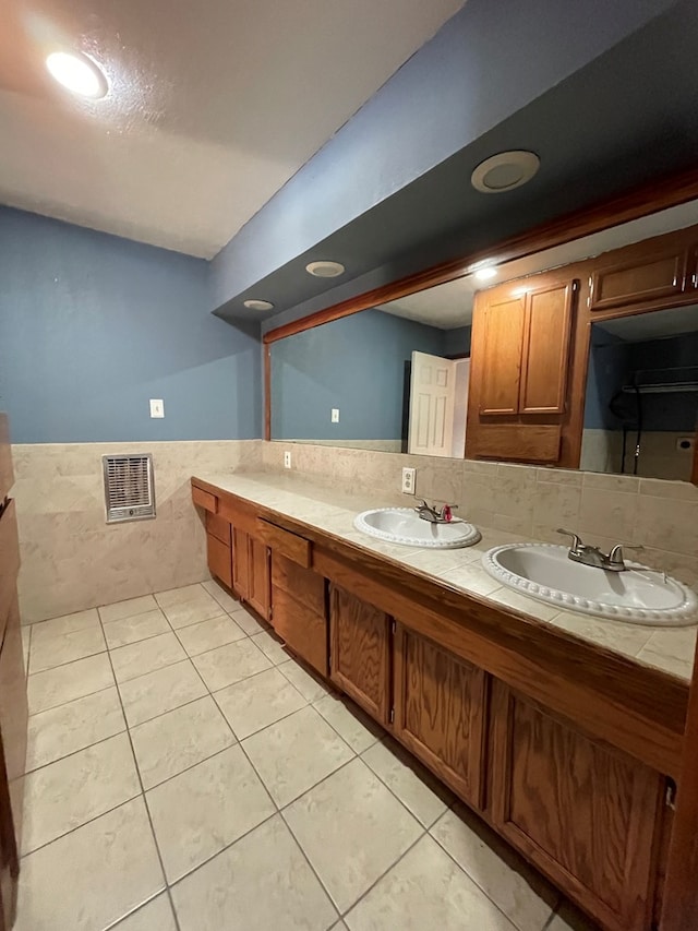 bathroom featuring double vanity, a wainscoted wall, tile patterned flooring, and a sink