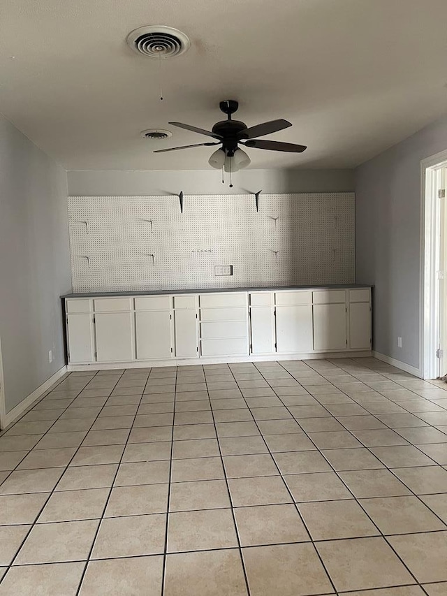 empty room with visible vents, ceiling fan, baseboards, and light tile patterned flooring