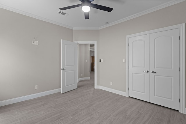 unfurnished bedroom featuring a closet, light hardwood / wood-style floors, ceiling fan, and ornamental molding