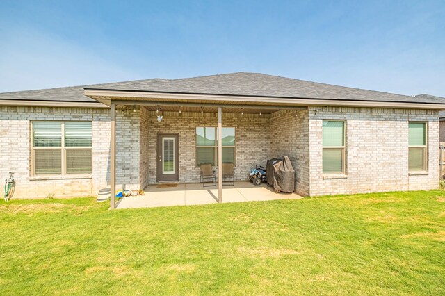 back of house with a patio area and a lawn