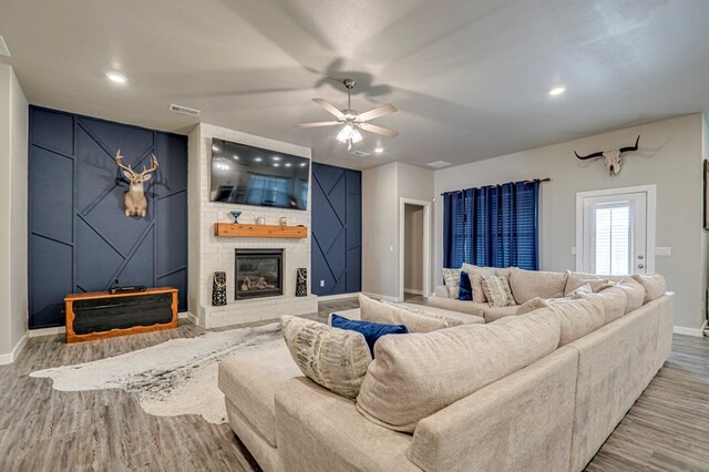 living room with a fireplace, hardwood / wood-style floors, and ceiling fan