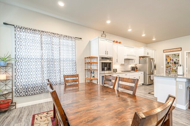 dining area with sink and light wood-type flooring