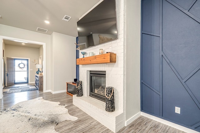 living room featuring dark hardwood / wood-style flooring and a brick fireplace