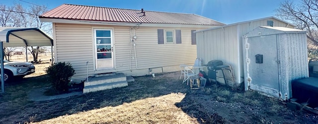 back of house featuring entry steps and metal roof