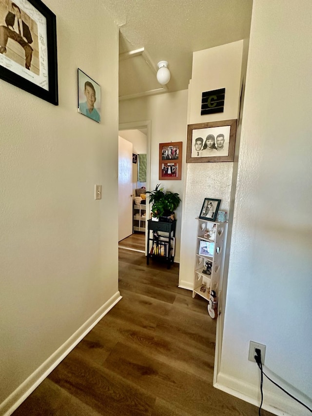 hall with dark wood-type flooring and baseboards