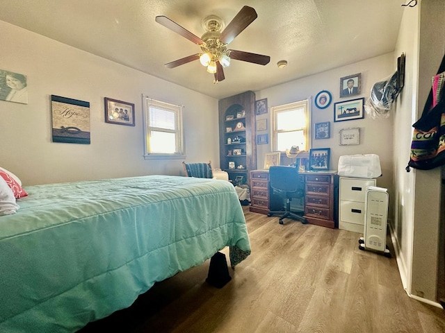 bedroom with ceiling fan and light wood-style flooring