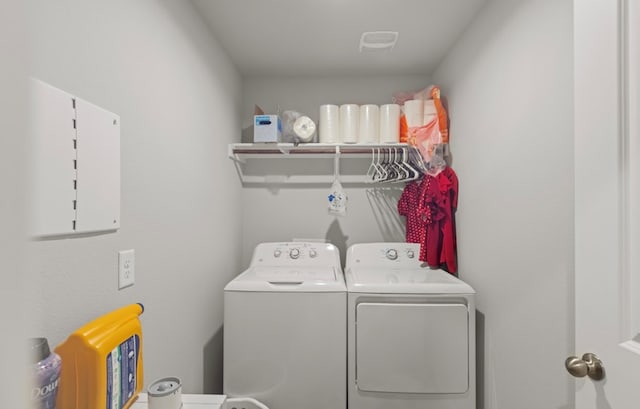 laundry area featuring electric panel and separate washer and dryer