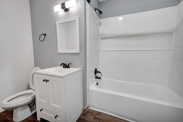 full bathroom with tiled shower / bath combo, wood-type flooring, vanity, and toilet